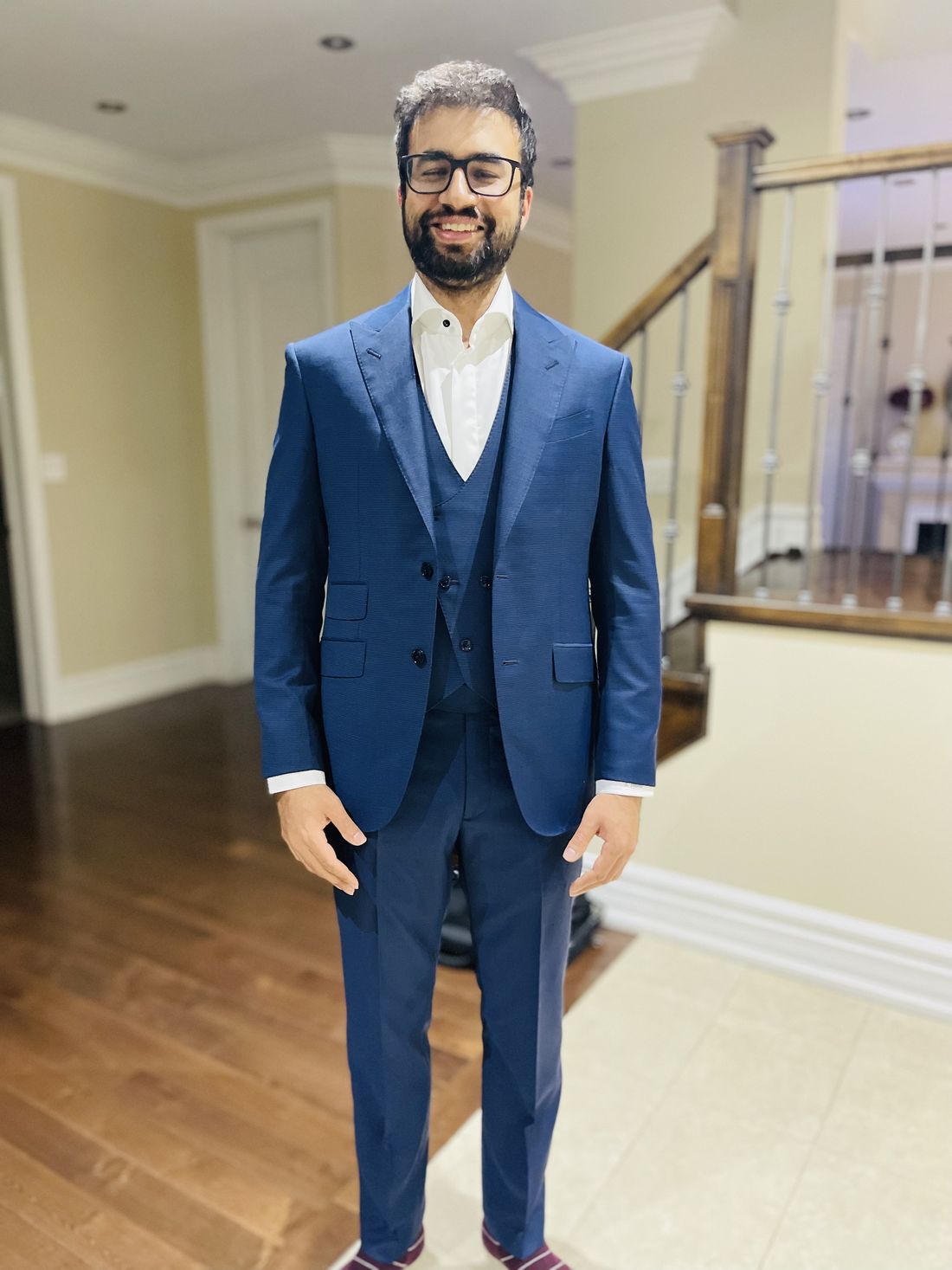 Client in a navy bespoke three-piece suit at home